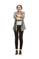 Image showing Full length portrait of a surprised female student holding books isolated on white background