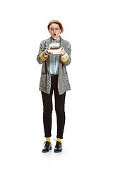 Image showing Full length portrait of a surprised female student holding books isolated on white background