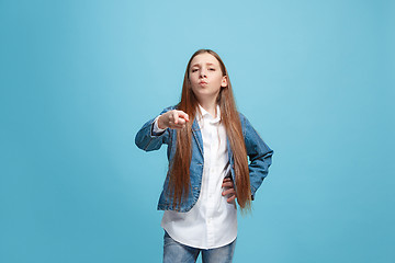 Image showing The happy teen girl pointing to you, half length closeup portrait on blue background.