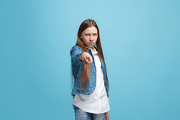 Image showing The happy teen girl pointing to you, half length closeup portrait on blue background.