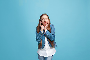 Image showing Beautiful teen girl looking suprised isolated on blue