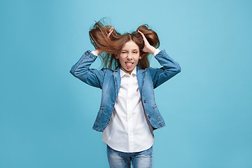 Image showing The squint eyed teen girl with weird expression isolated on blue