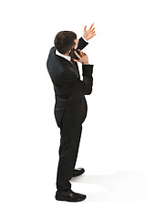 Image showing Back view portrait of a businessman. Confident professional with mobile phone