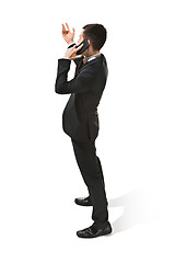 Image showing Thee profile portrait of a businessman with very serious face. Confident professional with mobile phone