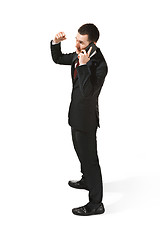 Image showing Thee profile portrait of a businessman with very serious face. Confident professional with mobile phone