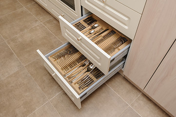 Image showing Opened kitchen drawer with silverware