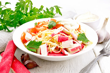 Image showing Salad of surimi and tomatoes on wooden table