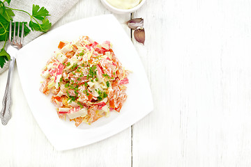 Image showing Salad of surimi and tomatoes with mayonnaise on wooden board top