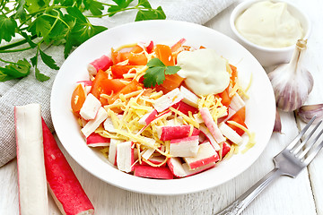 Image showing Salad of surimi and tomatoes on light wooden board