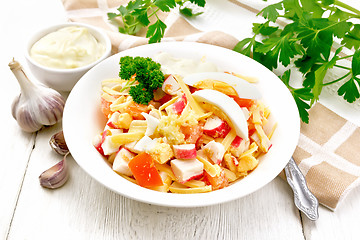 Image showing Salad of surimi and tomatoes with eggs on wooden board