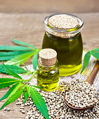 Image showing Oil hemp in two jars on wooden table