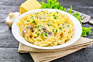 Image showing Fusilli with mushrooms and cream on black board