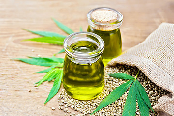 Image showing Oil hemp in two jars with green sheet on board