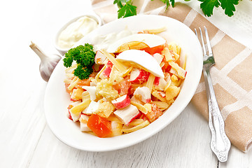 Image showing Salad of surimi and tomatoes with eggs on wooden table