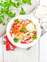 Image showing Salad of surimi and tomatoes on light board top