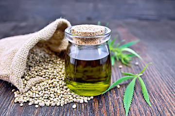 Image showing Oil hemp in jar with seed in sack on board