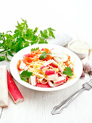 Image showing Salad of surimi and tomatoes on light wooden table