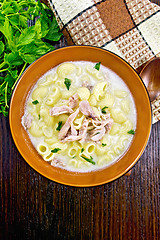 Image showing Soup creamy of chicken and pasta in plate on dark board top