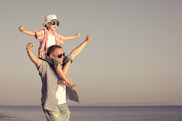 Image showing Father and son playing on the beach at the day time.