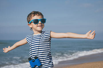 Image showing One happy little boy playing on the beach at the day time.