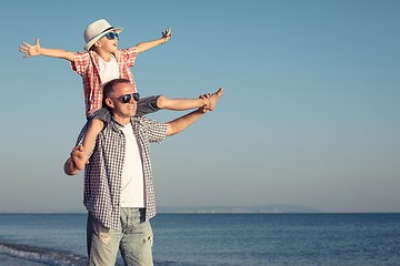 Image showing Father and son playing on the beach at the day time.