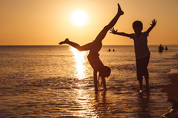 Image showing Happy children playing on the beach at the sunset time.