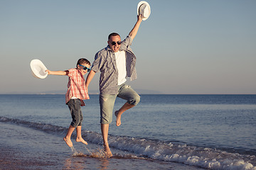 Image showing Father and son playing on the beach at the day time.