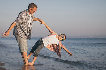 Image showing Father and son playing on the beach at the day time.