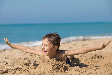 Image showing One happy little boy playing on the beach at the day time.