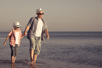 Image showing Father and son playing on the beach at the day time.