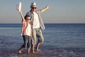 Image showing Father and son playing on the beach at the day time.