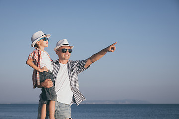 Image showing Father and son playing on the beach at the day time.