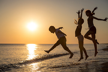 Image showing Happy children playing on the beach at the sunset time.