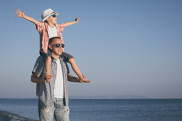 Image showing Father and son playing on the beach at the day time.