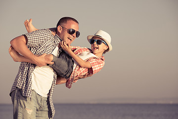 Image showing Father and son playing on the beach at the day time.