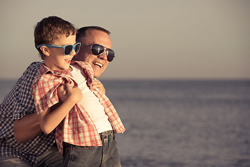 Image showing Father and son playing on the beach at the day time.