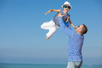 Image showing Father and son playing on the beach at the day time. 