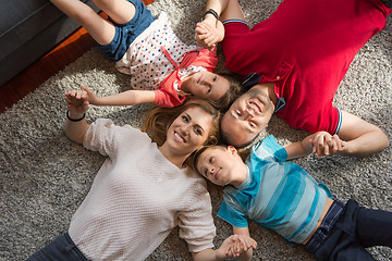 Image showing happy family lying on the floor