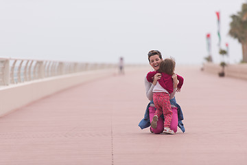 Image showing mother and cute little girl on the promenade by the sea