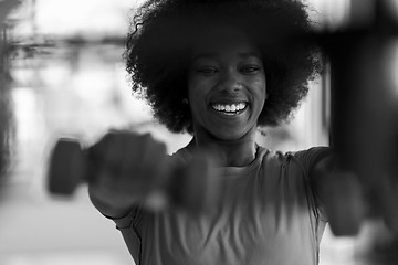 Image showing woman working out in a crossfit gym with dumbbells