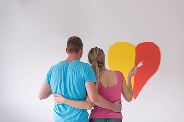 Image showing couple are painting a heart on the wall