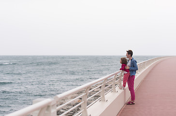 Image showing mother and cute little girl on the promenade by the sea