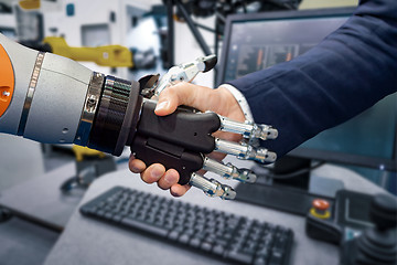 Image showing Hand of a businessman shaking hands with a Android robot.