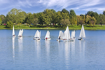 Image showing The small sailing ships regatta on the blue lake