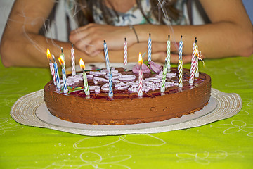 Image showing Young girl is to blow out candles on her birthday cake