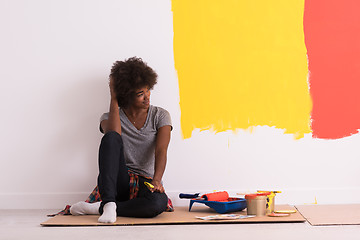 Image showing back female painter sitting on floor