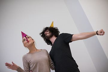 Image showing couple in party hats blowing in whistle