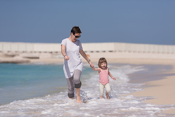 Image showing mother and daughter running on the beach