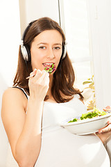 Image showing pregnant woman eat salad and listening to music