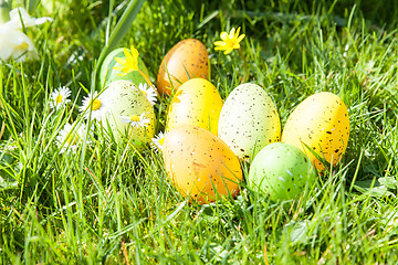 Image showing colored Easter eggs hidden in flowers and grass